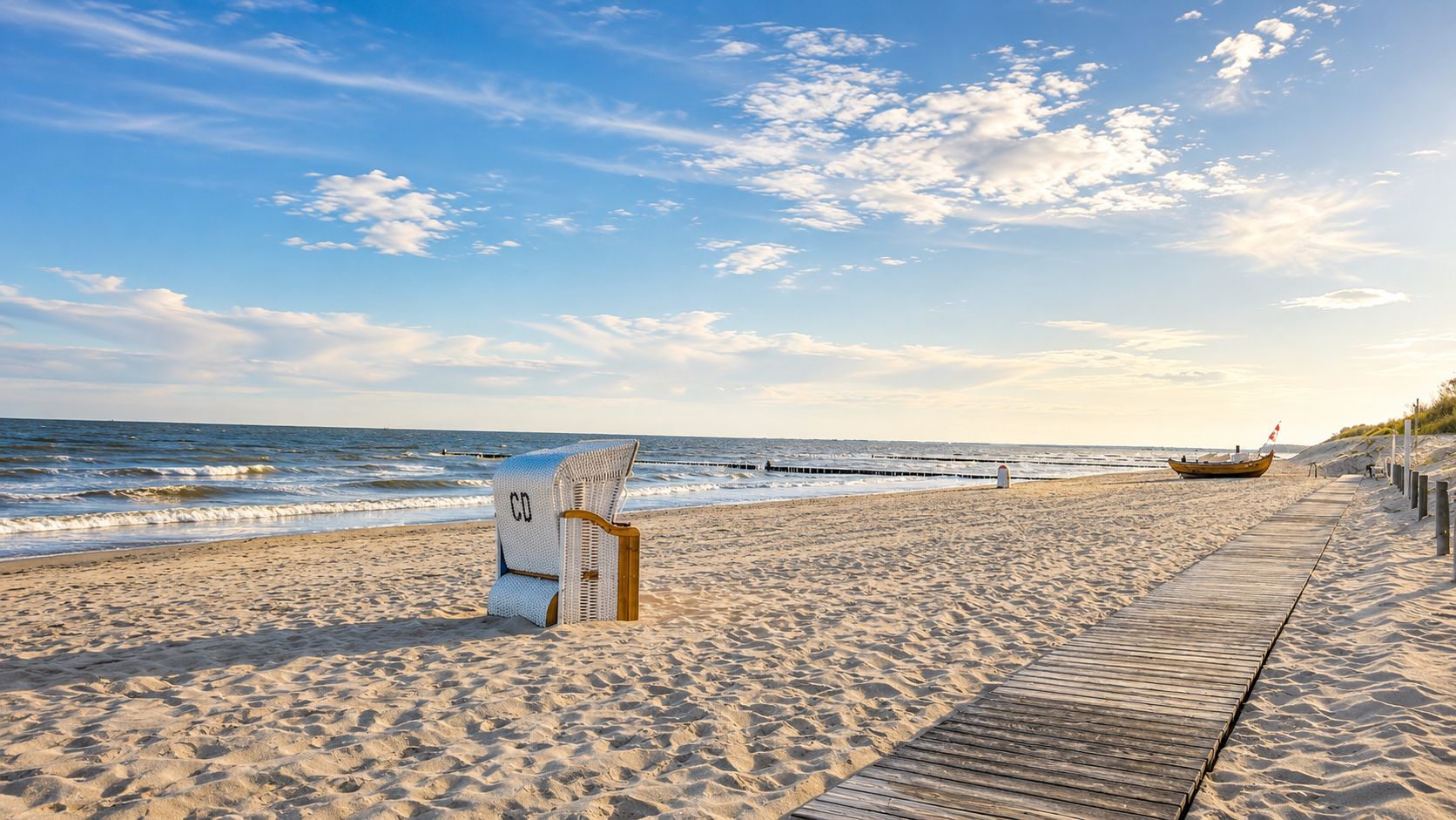 Strandpromenade am Ostseestrand in Kölpinsee mit Strandkorb, Holzweg und Blick auf das Meer