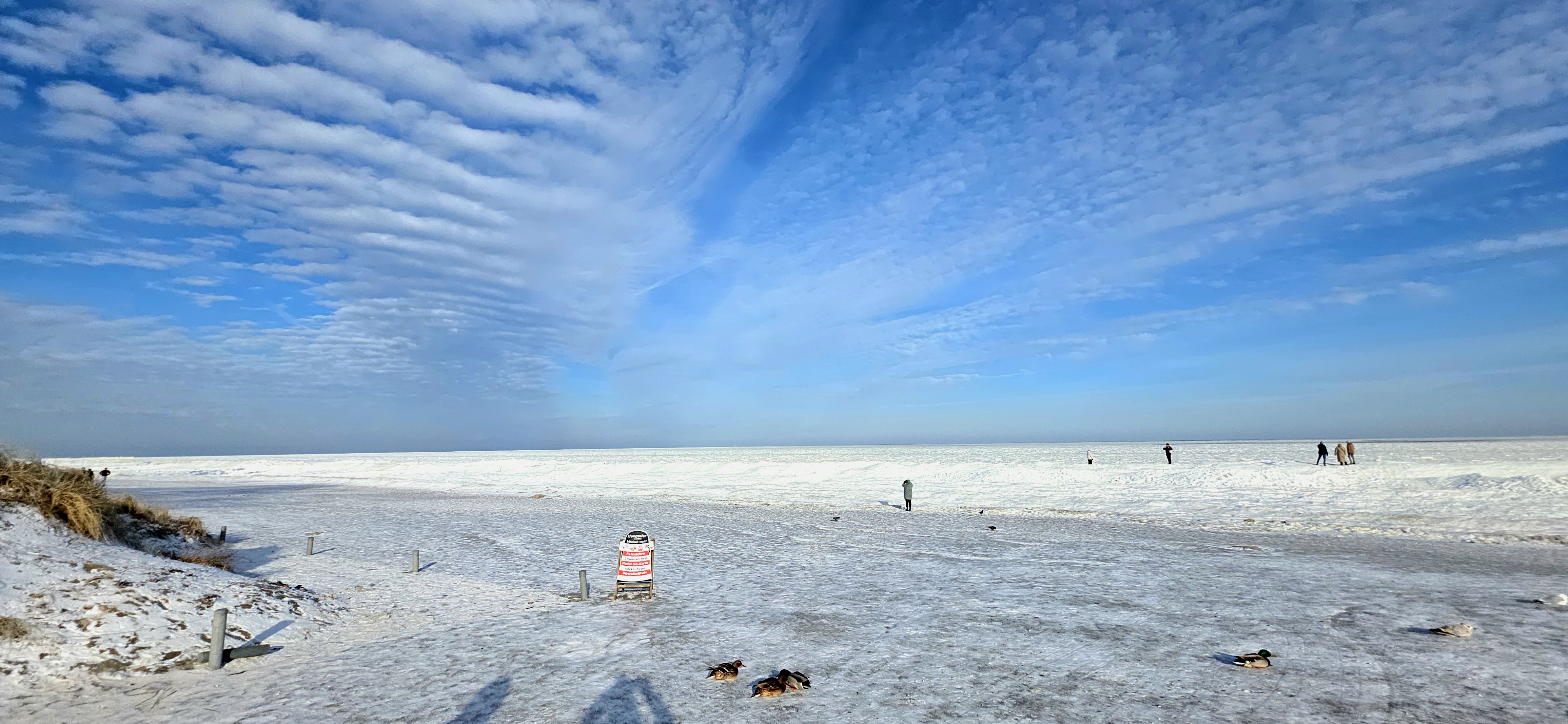 Gefrorene Ostsee bei Kölpinsee mit weitem Blick über Eis, Strand und Himmel
