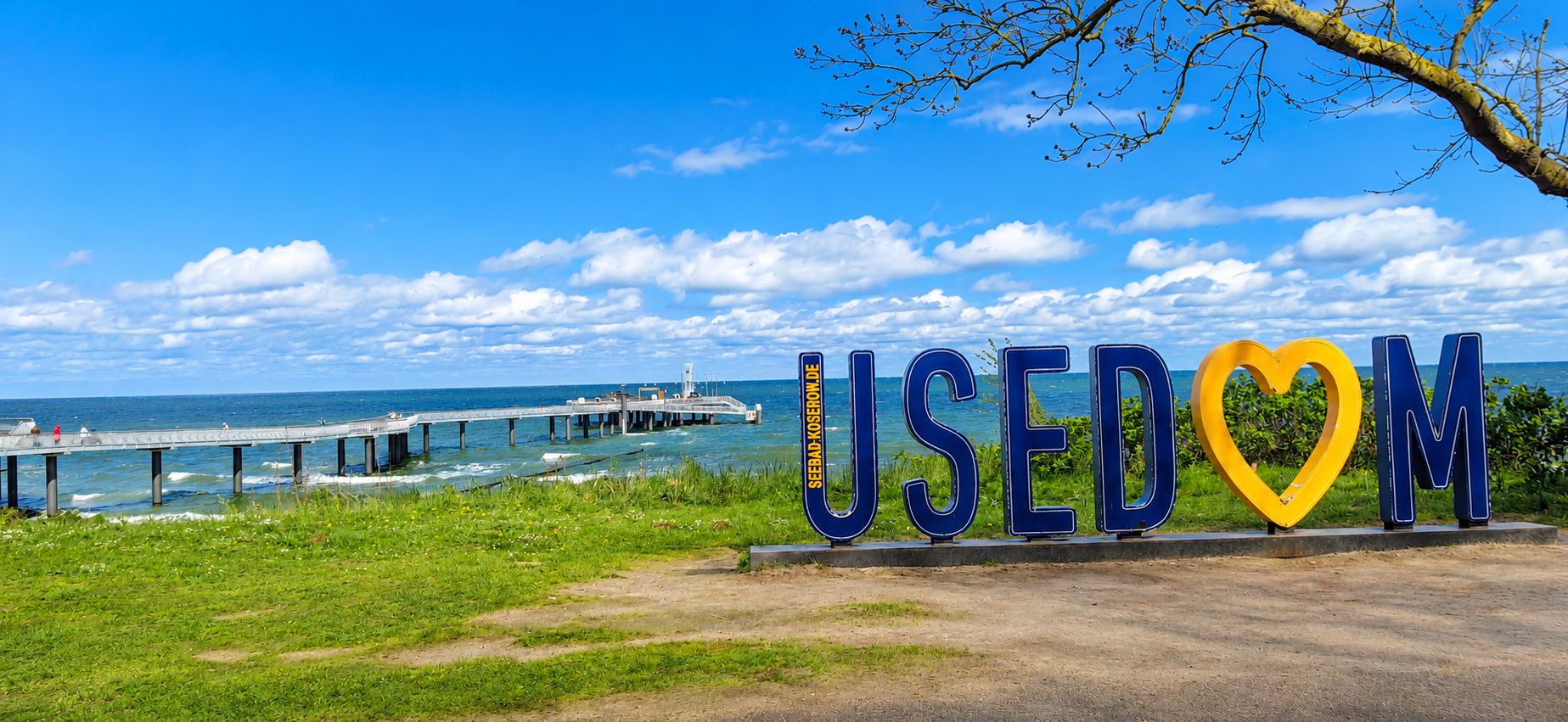 Seebrücke in Koserow auf Usedom mit Blick auf die Ostsee und dem großen Usedom-Schriftzug im Vordergrund